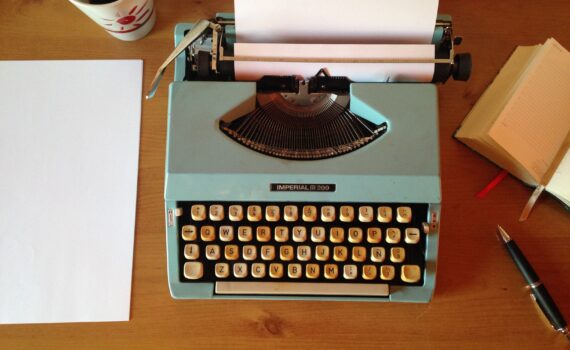 machine à écrire avec papier sur bureau en bois